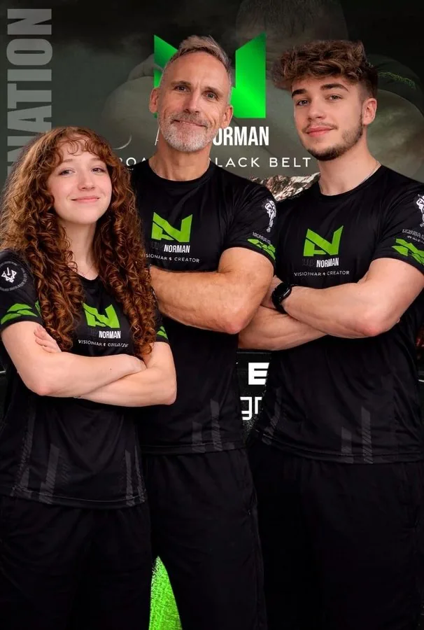 Teamfoto: Andy Norman mit zwei jungen Trainern in Defence-Lab-Shirts